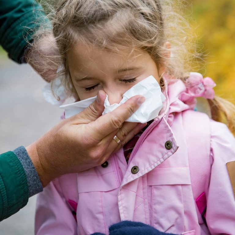 Child sneezing in handkerchief